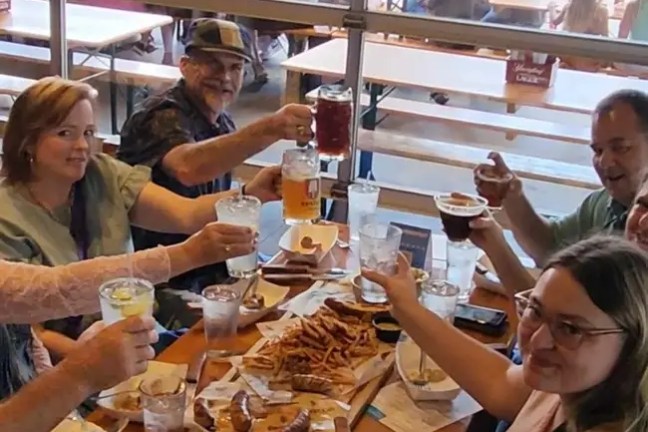 Group enjoying drinks and food at a restaurant table.