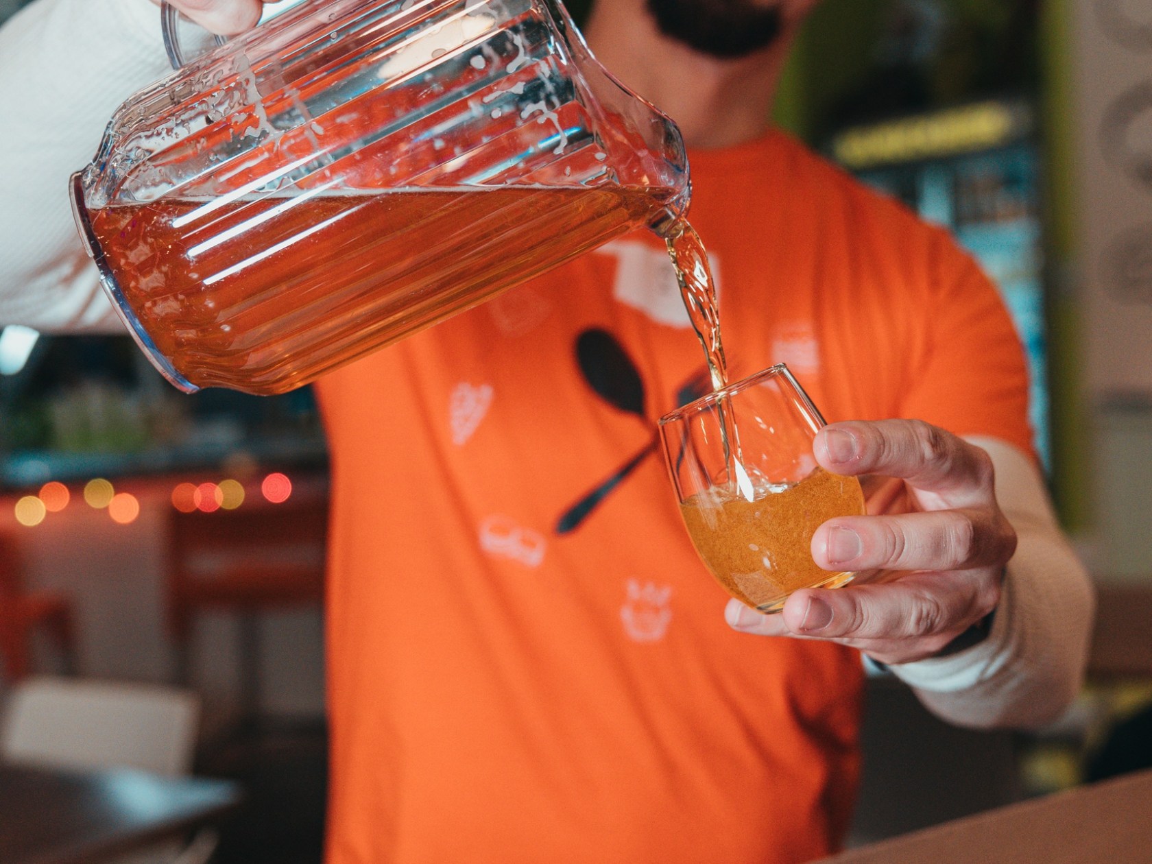 Man pouring beer into a glass from a pitcher